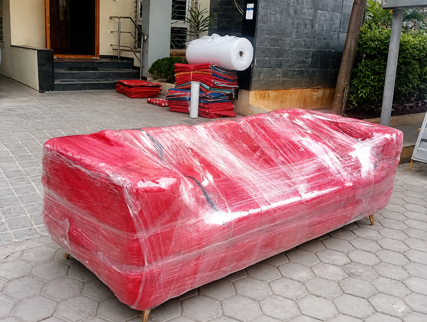 Red sofa fully protected with stretch wrap before moving